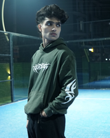 Person wearing a green hoodie with white graphics on a sports court at night